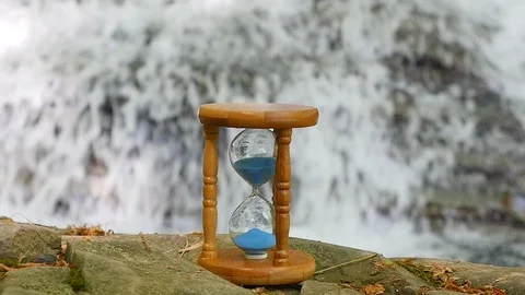 Hourglass on the Background of a Mountain River 스톡 동영상 88966048