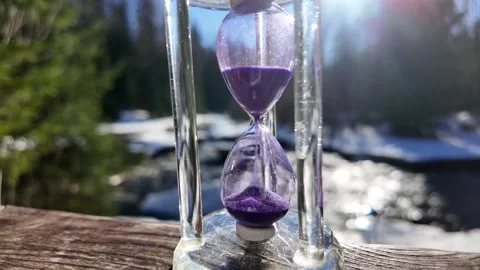 Hourglass on the background of the river. Slowmotion Video stock 334058999