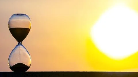 Hourglass on the background of a sunset. The value of time in life. An eterni Stock Photos