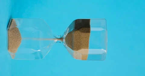 Hourglass on blue background. Time is up. Time and transience concept. Stock Footage 105306544