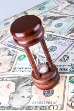 Hourglass on dollars Stock Photos