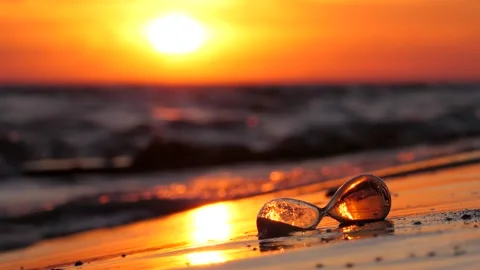 Hourglass falling on the beach at sunset, washed by small wave Stock Footage 314250897