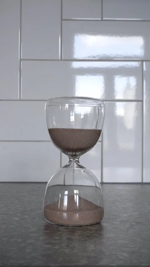 Hourglass with falling sand on bright background Stock Footage 335781098