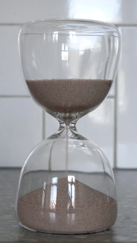 Hourglass with flowing sand on light background Stock Footage 335781126