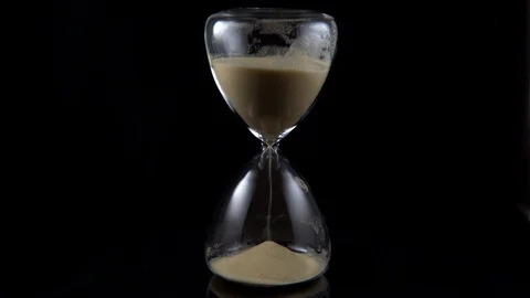 Hourglass infront of black background Stock Footage 123862428