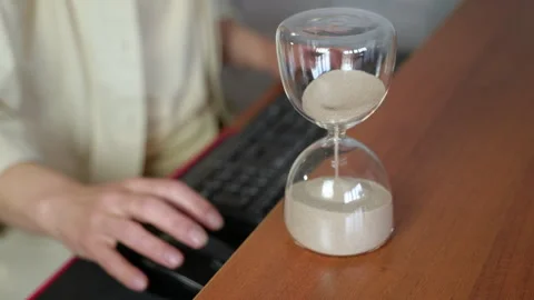 Hourglass measuring time during office work Stock Footage 345113928