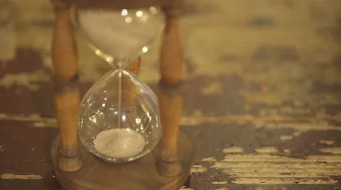 Hourglass on old table Stockbeeldmateriaal 61772593