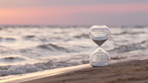Hourglass passing time on beach at soft sunset Stock Footage 314251550