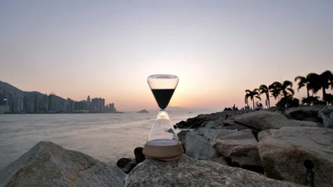 Hourglass passing time during sunset at Victoria Harbour, time lapse Stock Footage 304654715