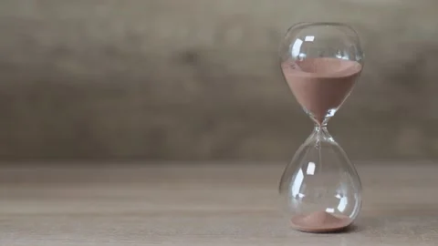 Hourglass, on the right side of the frame, sand pouring from top to bottom Video stock 205001283