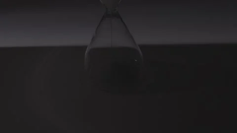 Hourglass Sand Falling Through Narrow Neck on White Surface Vídeos de archivo 336550416