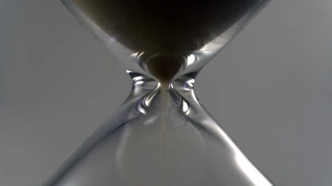 Hourglass sand running through extrem close up infront of white Video stock 122991902