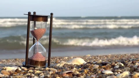 Hourglass on a sandy beach with ocean waves background Stock Footage 336399609