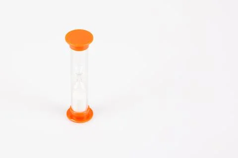 Hourglass sandy timer in plastic orange in grey background with white sand Stock Photos