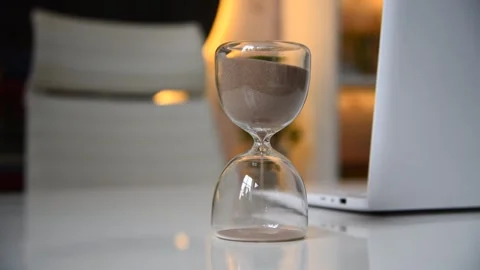 Hourglass stands on white table Stock Footage 250848608