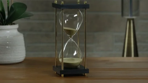 Hourglass on a table Stockbeeldmateriaal 113935696