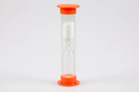 Hourglass timer orange in plastic in grey background with white powder sand d Foto stock