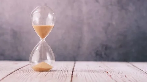 Hourglass timer showing passage of time with sand flowing through glass bul.. Stock Footage 333029947
