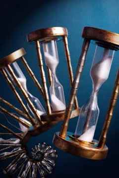 Hourglasses fliping in spiral on a blue background Stock Photos