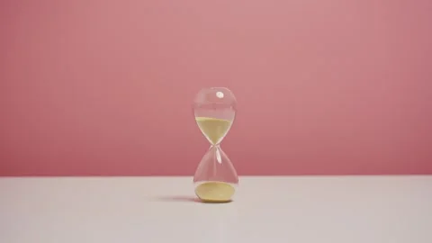 Hourglasses on table with isolated pink background. Stock Footage 310228443