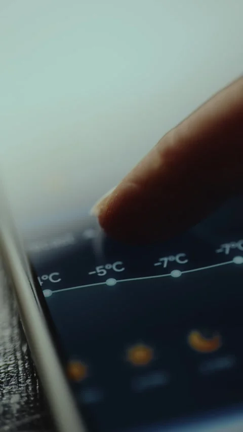 Hourly forecast showing values below zero, finger interacting with a weather app Stock Footage 327450655