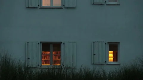 House and it's windows while light bulbs are on inside Stock Footage 51673877