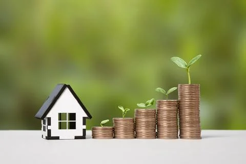 House and stack of coins Stock Photos