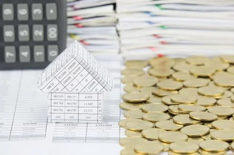 House and stack of gold coins with blur calculator Stock Photos