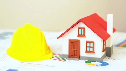 A house and a yellow construction worker's hard hat are on the reports and Stock Footage 335836965