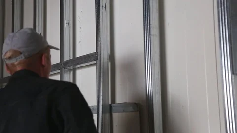 House attic insulation - construction worker installing rock wool in mansard Stockbeeldmateriaal 128497473