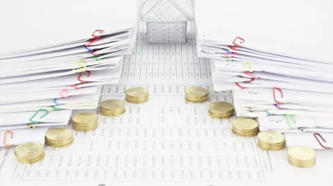 House between pile of paperwork and gold coins time lapse Stock Footage 53760359