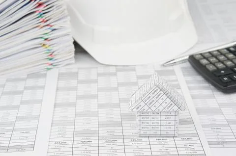 House with blur white engineer hat and pile overload document Stock Photos