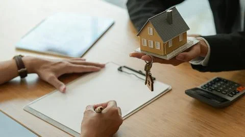 House broker is introducing the client to sign the purchase contract. Stock Photos