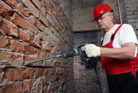 House-builder in uniform working with a plugger Stock Photos