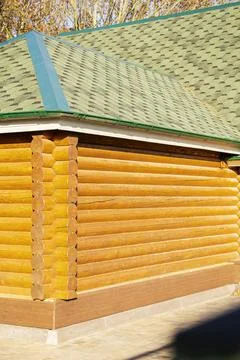 The house is built of round logs. Close-up of the corner of the house Stock Photos