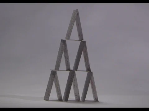 A house of cards being blown off, white background, slow motion, m/s Stock Footage 74098723