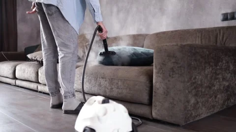 House cleaning. A man cleans the sofa and furniture with a steam generator. Stock Footage 271145782