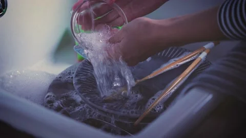 House Cleaning routine. Water streaming on dishes in kitchen sink. Hand washing  Stock Footage 143018587