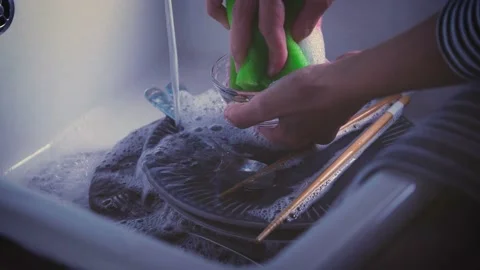 House Cleaning routine. Water streaming on dishes in kitchen sink. Hand washing  Stock Footage 143019008