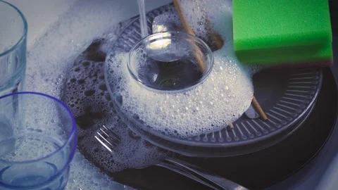 House Cleaning routine. Water streaming on dishes in kitchen sink. Hand washing  Stock Footage 143242157