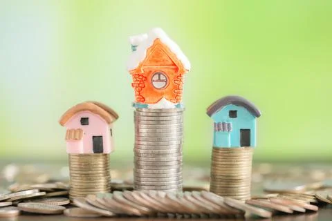 House with coins stack on bokeh background Stock Photos