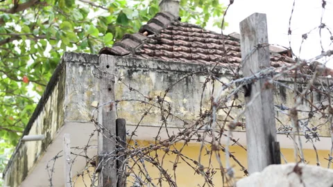 House corroded by damp behind barbed wire fence. Stock Footage 295775153