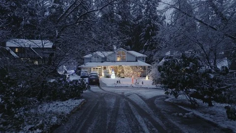 House decorated with Christmas lights, dusk, snowing Stock Footage