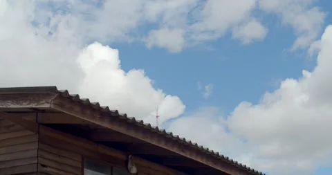 House eaves and clear blue sky.Cloud relaxation weather dramatic beauty atmosphe Stock Footage 250073544