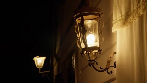 House facade close up on classic old style lamps or lanterns glowing in dark Vídeo Stock 308668833
