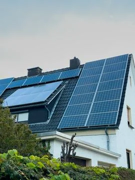 A house features multiple solar panels on its roof, demonstrating the use of  Foto stock