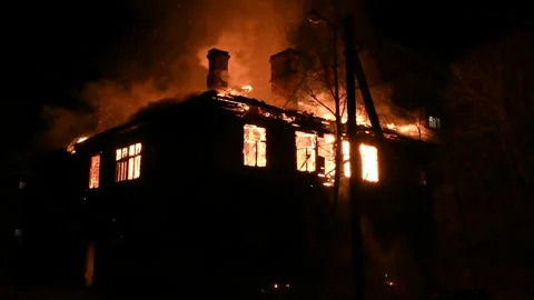 House is on fire at night, flames inside at home, burning windows. Stock Footage 294688275