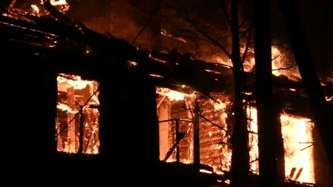 House is on fire at night, flames inside at home, burning windows. Stock Footage 294688277