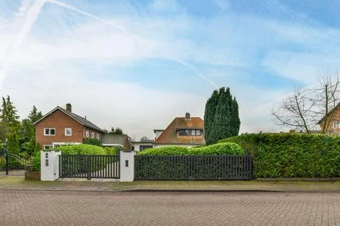 A house with a gate in front of a driveway Stock Photos