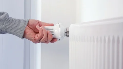 House heating - Hand turns the heating thermostat Stock Footage 88386952